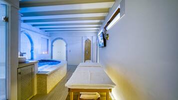 A spa area with a massage table, a hot tub, and a reception desk.