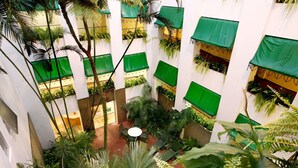 A multi-level atrium with green canopies, indoor plants, and a central seating area.