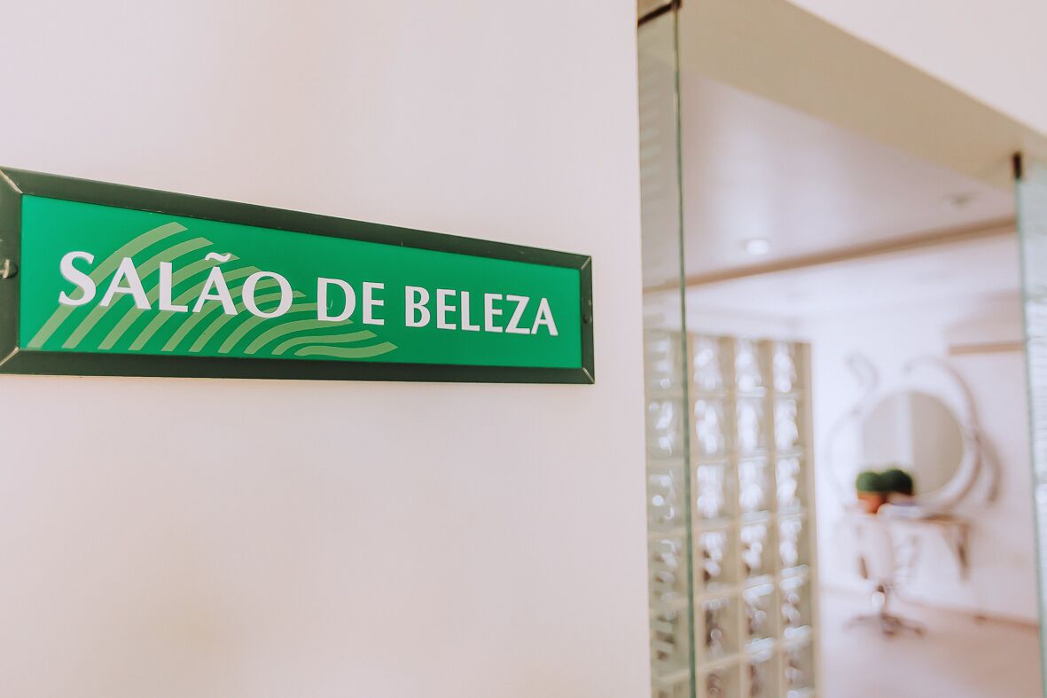 Una señal que indica 'SALÃO DE BELEZA' en un entorno hotelero.