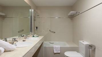 Un baño moderno con lavamanos doble, bañera y retrete.