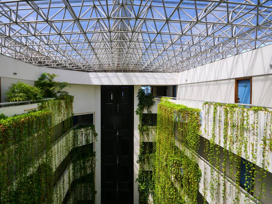 Un edificio moderno con techo de vidrio y jardines verticales.
