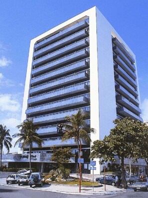 A multi-story building with a modern architectural design, featuring a series of balconies on each floor.