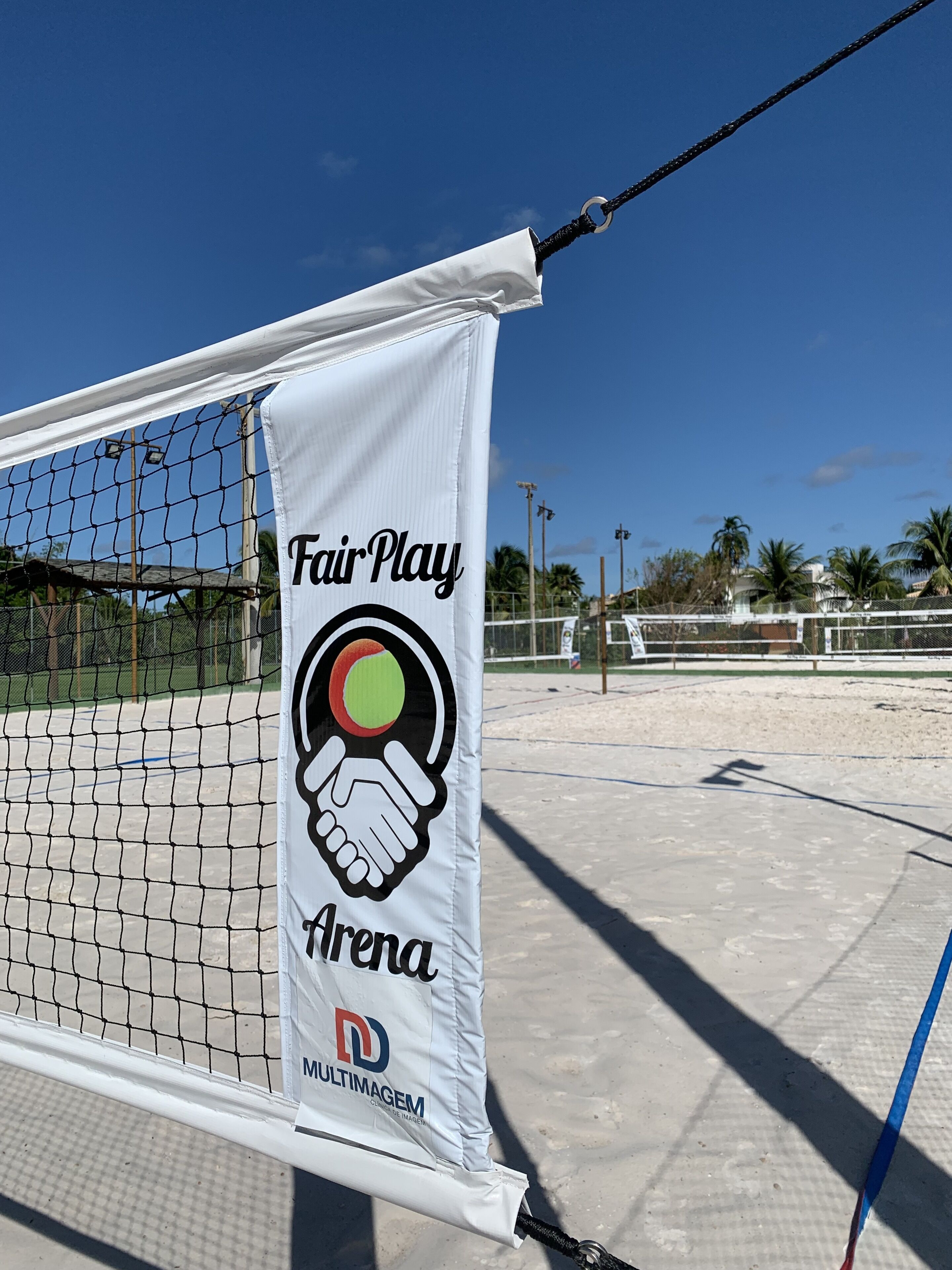 Una cancha de tenis con un cartel que dice 'Fair Play Arena' y un logotipo.