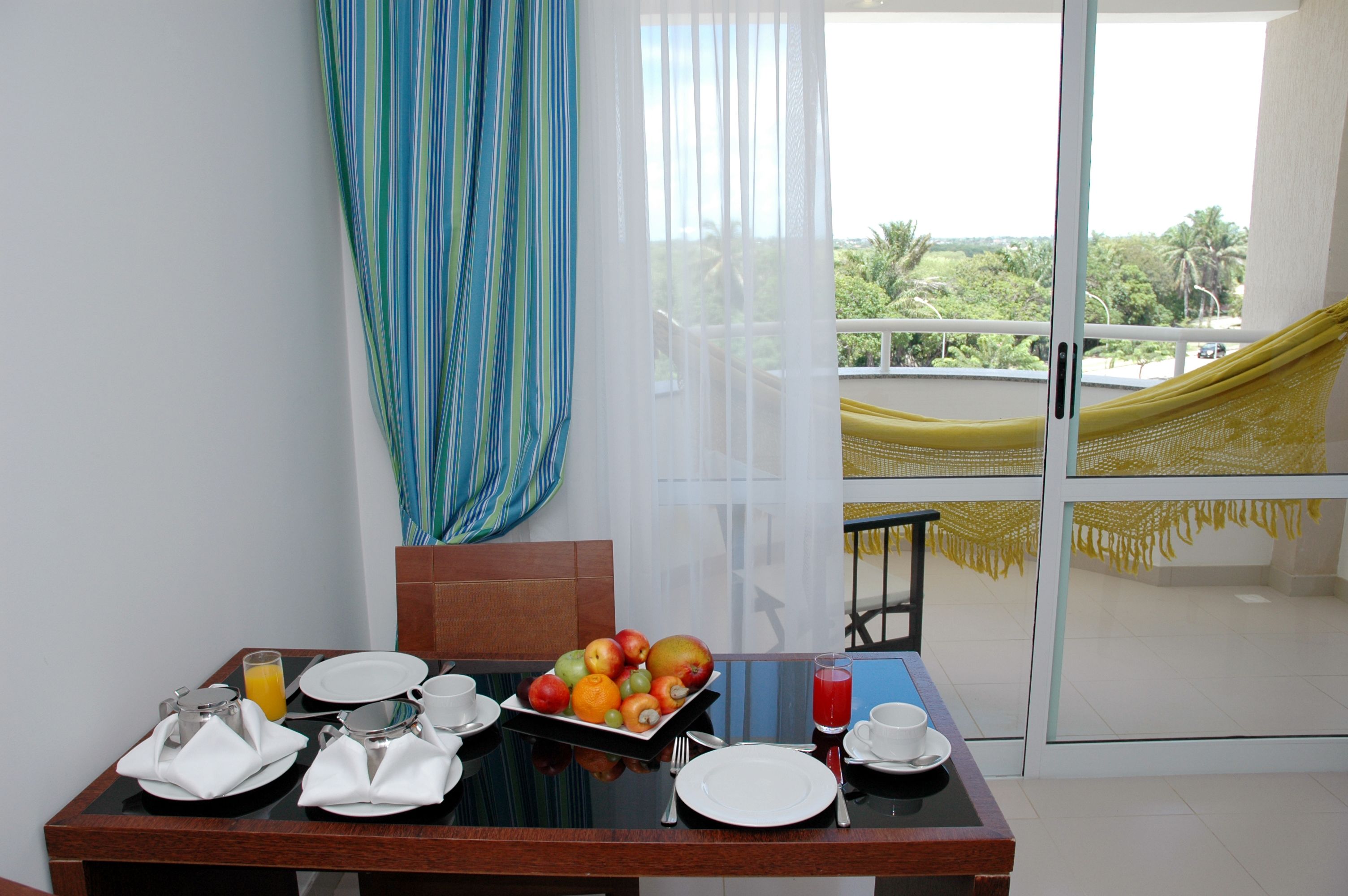 A dining table set with plates, cutlery, and a fruit bowl.