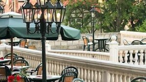 An outdoor cafe area with tables and chairs, covered by umbrellas, and a decorative railing in the background. - Schlosshotel Zum Markgrafen (Quedlinburg)
