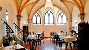 A dining area with high arched ceilings, multiple tables, and chairs. - Schlosshotel Zum Markgrafen (Quedlinburg)