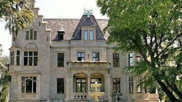 A large, historic building with a prominent fountain in front. - Schlosshotel Zum Markgrafen (Quedlinburg)