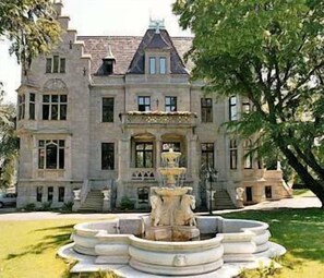 A large, historic building with a prominent fountain in front. - Schlosshotel Zum Markgrafen (Quedlinburg)