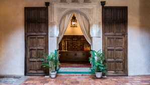 A traditional Moroccan interior with a wooden door, an ornate archway, and a hanging lantern. - Casa Morisca Hotel Boutique (Granada)