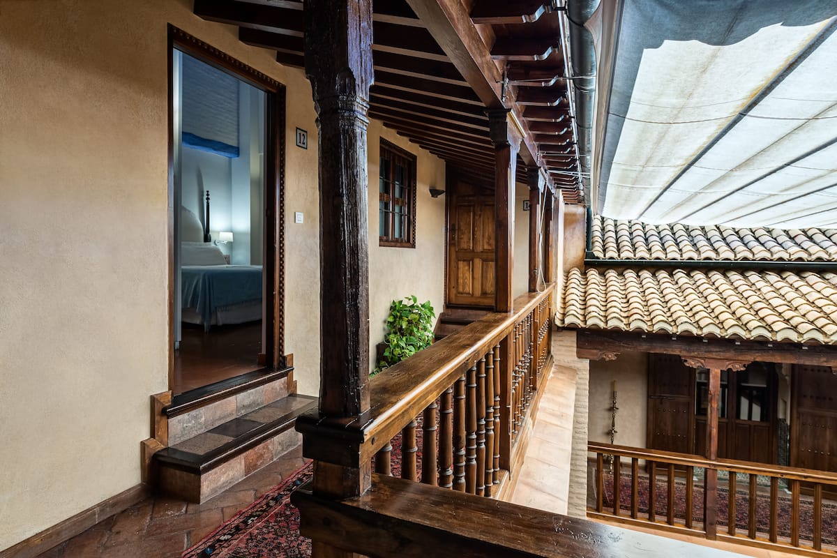 A wooden staircase with a railing leading to a balcony.