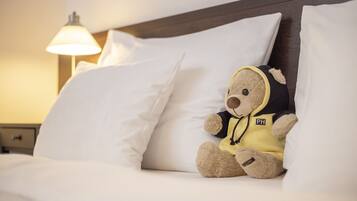 Relax in this inviting room with a plush bed, wooden headboard, and cozy bedside lamp.