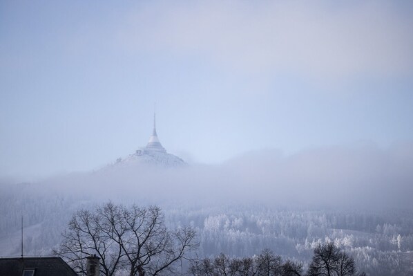 A snow-covered mountain with a tower in the distance.