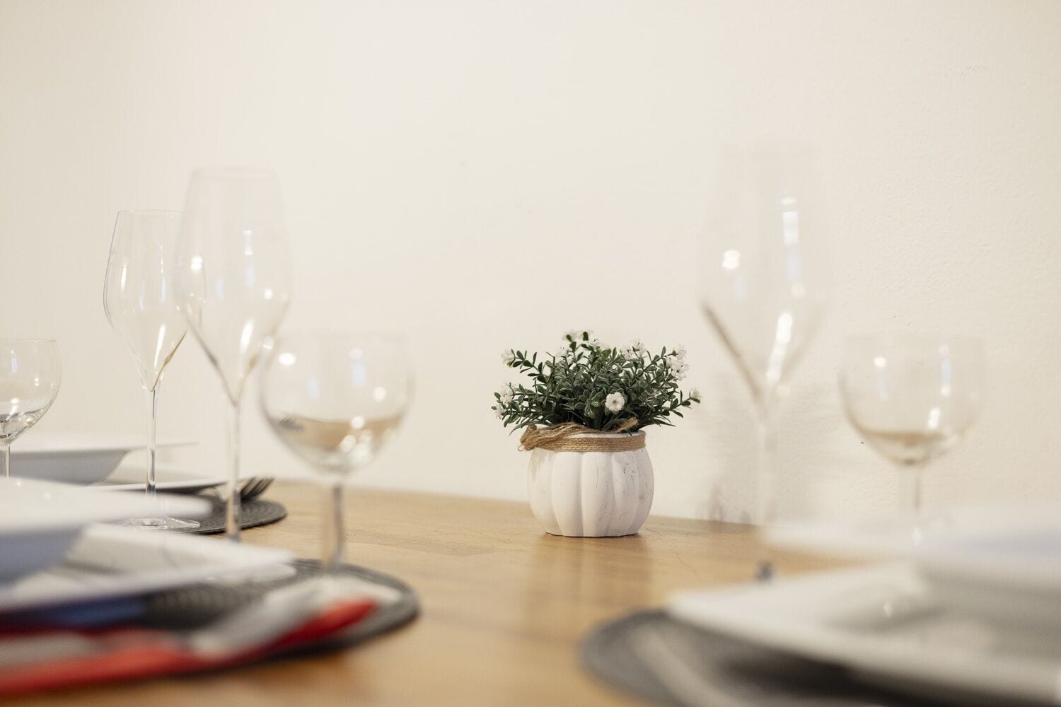 Une table avec des verres à vin et une petite plante en pot.
