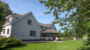 Een huis met twee verdiepingen en een overdekte patio.