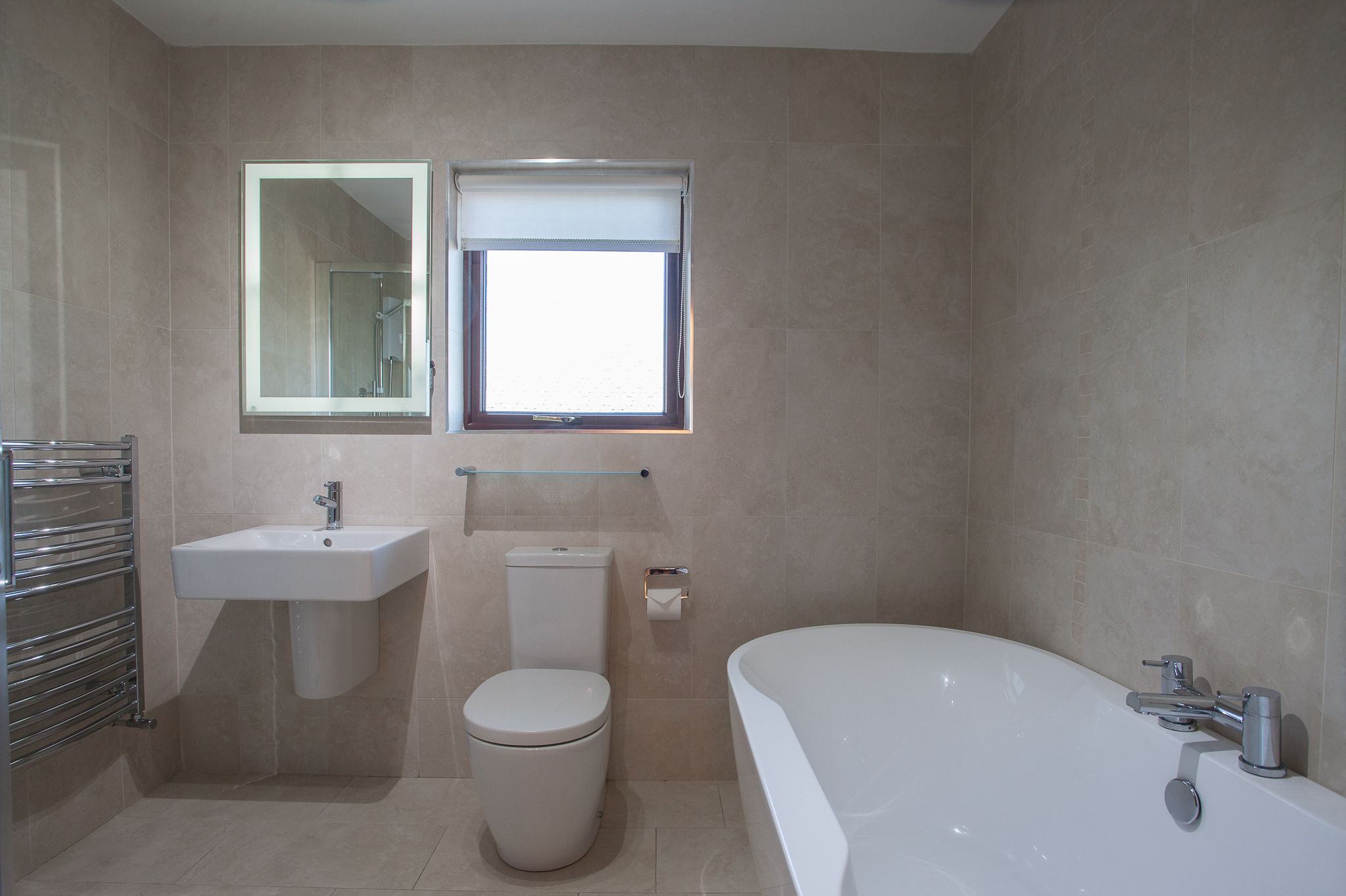 A modern bathroom with a sink, toilet, and bathtub.