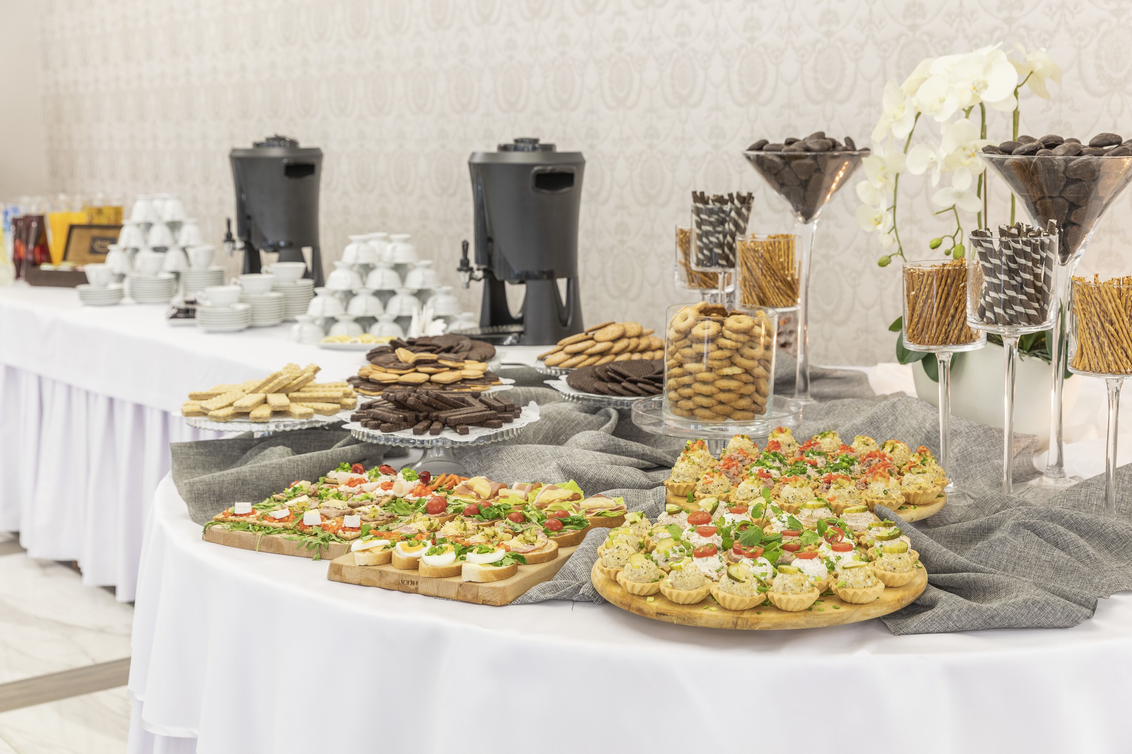 Una mesa de buffet con diversos alimentos, como galletas, pasteles y ensaladas.