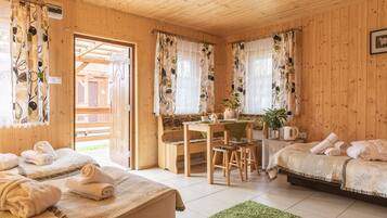 Una cabaña de madera con dos camas, una zona de comedor y un baño.