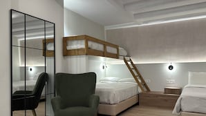 Un dormitorio con una cama litera, un sillón verde, un espejo y lámparas de noche.