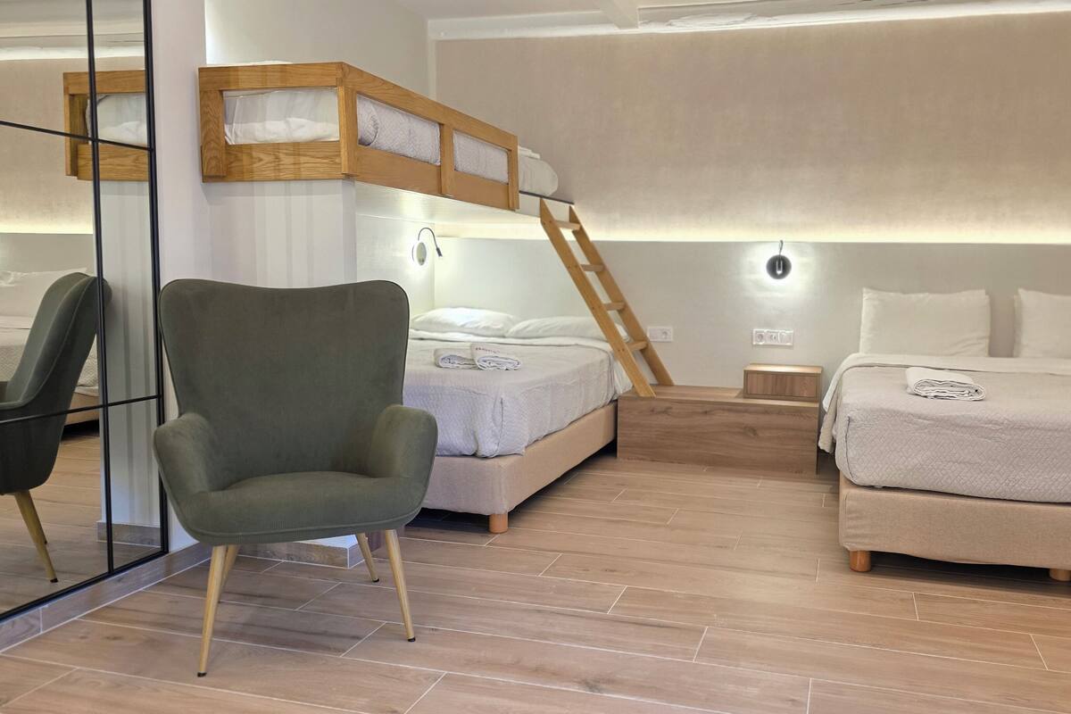Un dormitorio moderno con una cama individual, una litera, una silla y una mesita de noche.