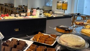A buffet with various desserts and a juice station.