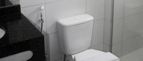 Un baño con inodoro, lavamanos y zona de ducha.