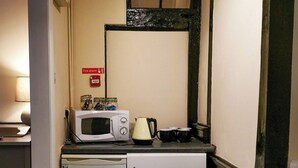 A compact kitchenette with a microwave, kettle, and small refrigerator. - The Olde Kings Arms (Hemel Hempstead)