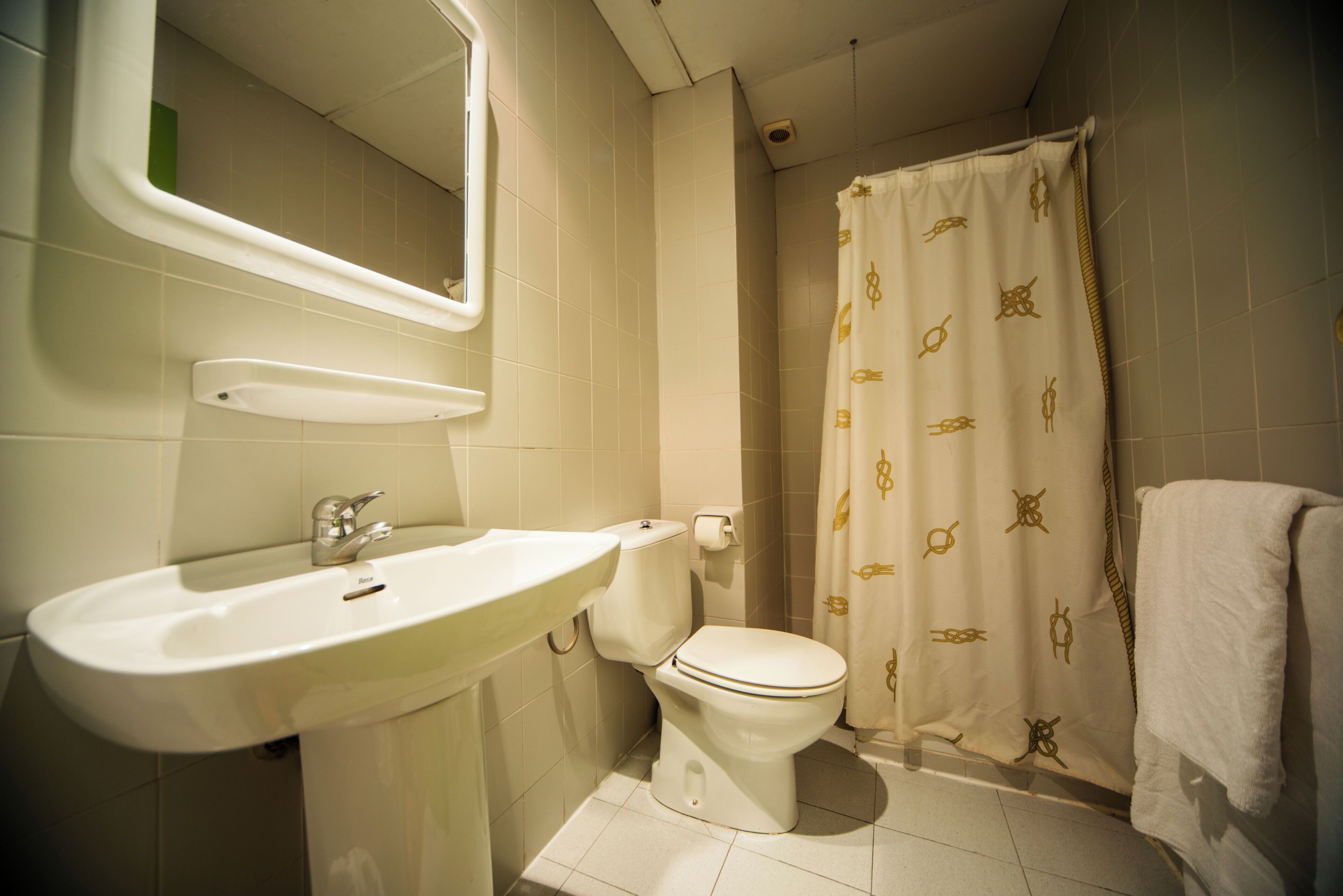 Een badkamer met wastafel, toilet en douchegordijn.