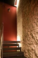 Una escalera con barandilla de metal que conduce a una pared roja.