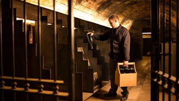 A person in a dimly lit, brick-walled room with a staircase.