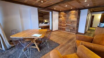 Una habitación acogedora con una mesa de comedor de madera, sillas y un sofá.
