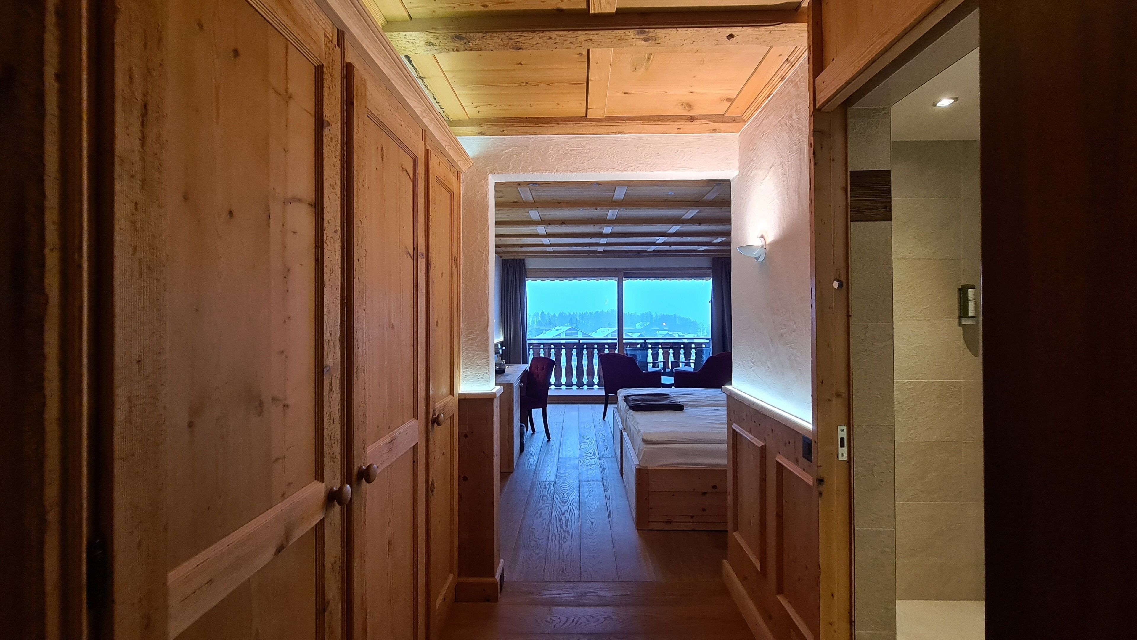 Un couloir en bois menant à un balcon avec vue.