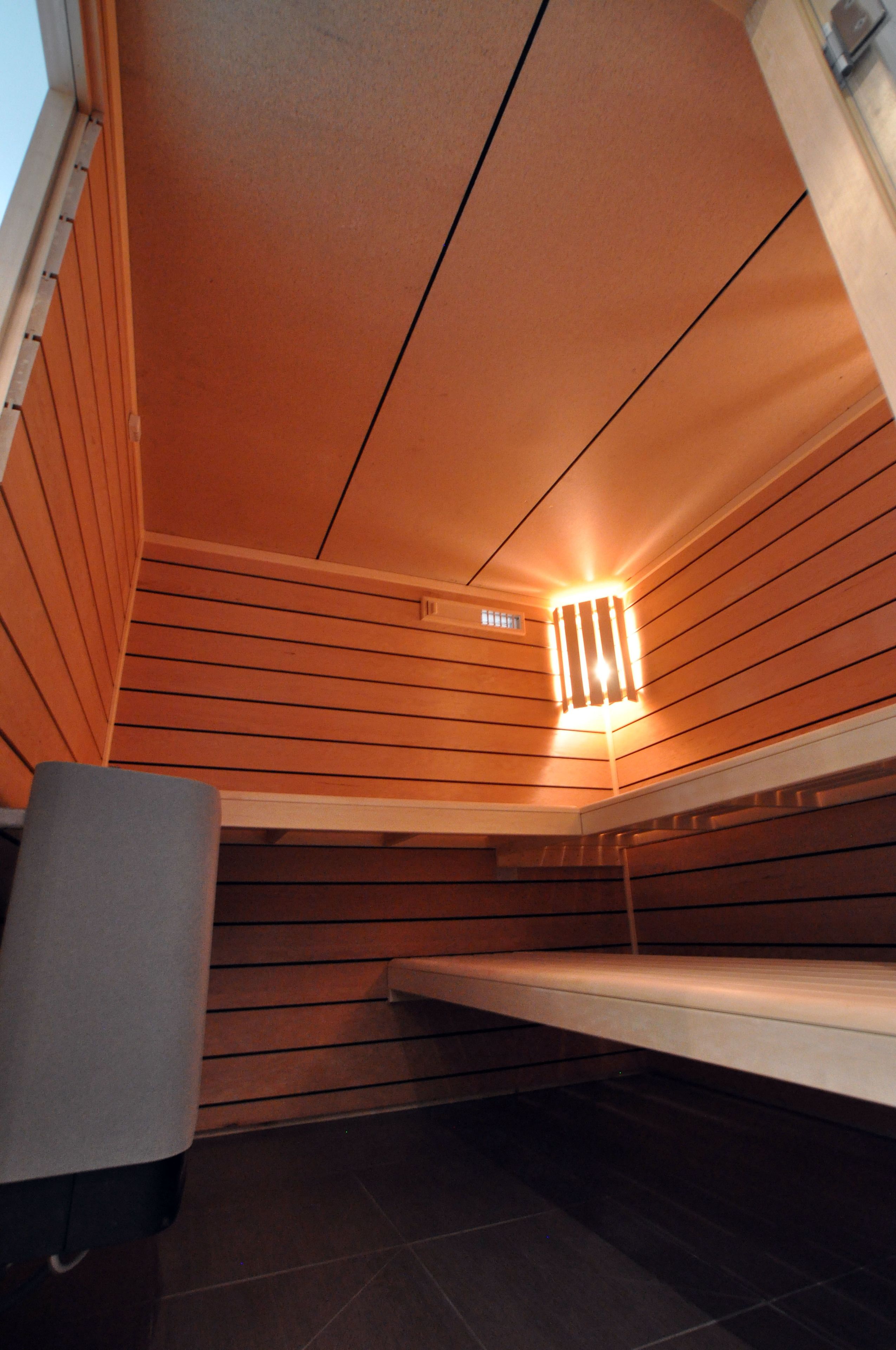 A room with wooden panel walls, a bench, and a ceiling light fixture.