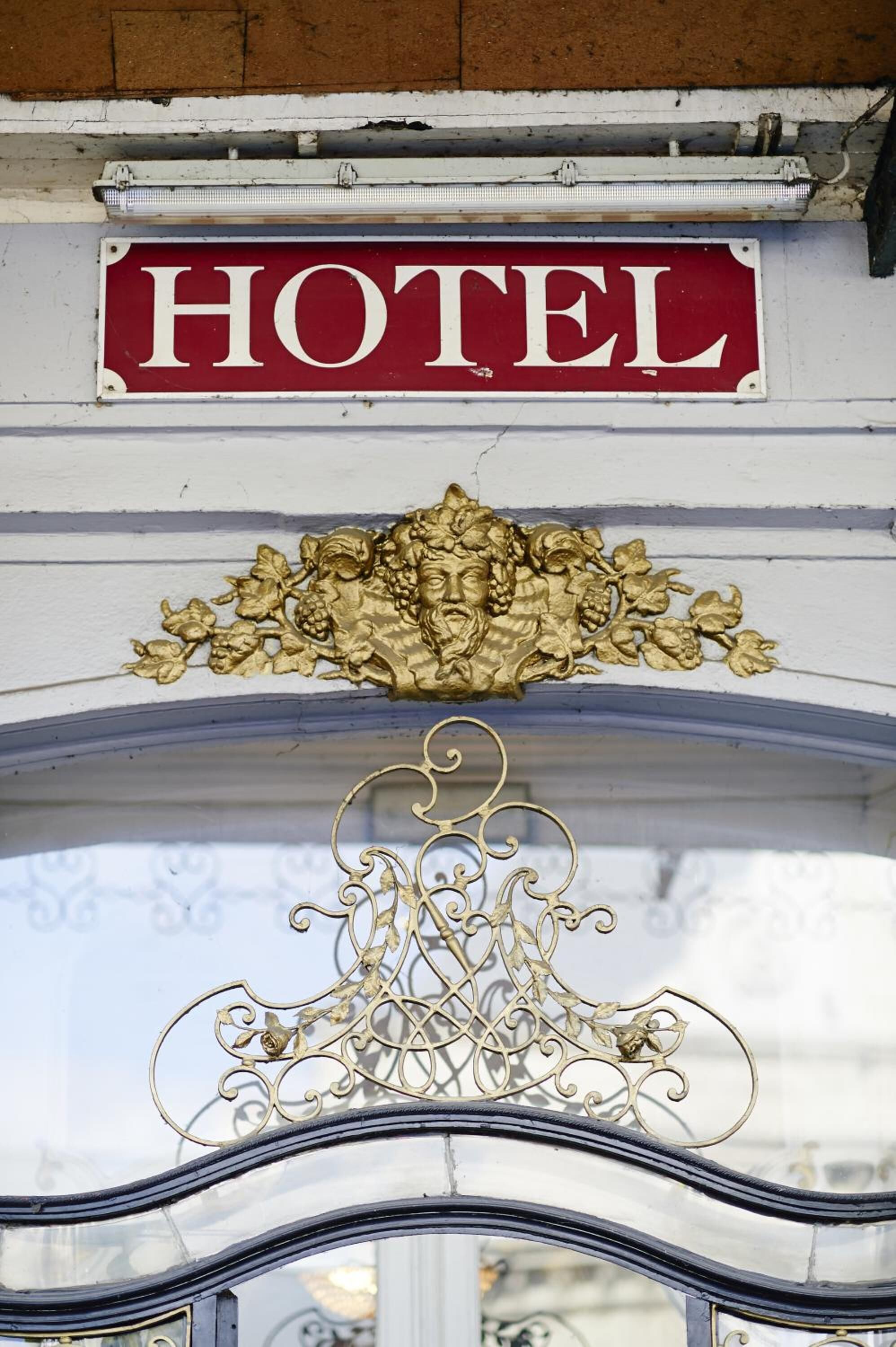 Un letrero de hotel con fondo rojo y letras blancas.