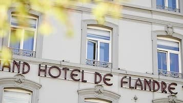 Classic hotel facade with a symmetrical design, large windows, and decorative moldings.