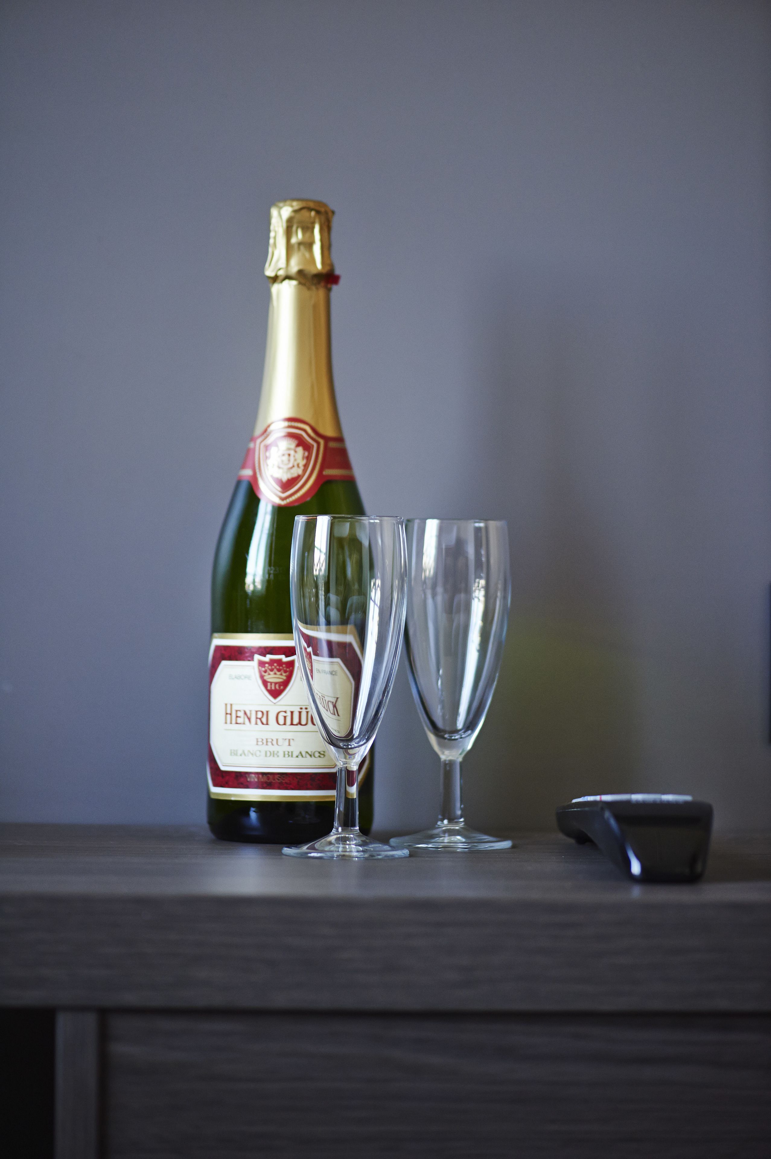 Une bouteille de champagne et deux verres sur une surface en bois.
