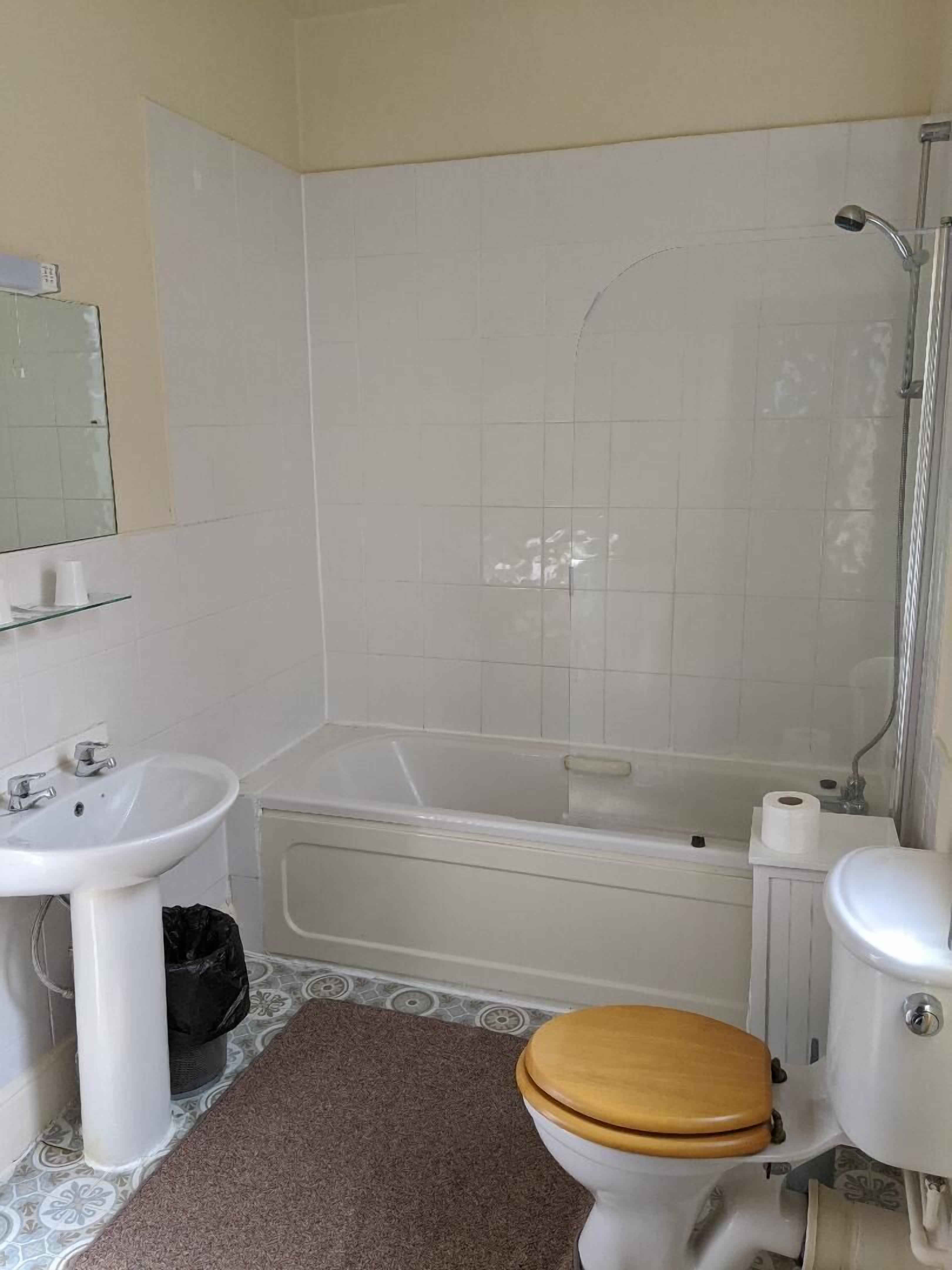 A bathroom with a white sink, toilet, and bathtub.