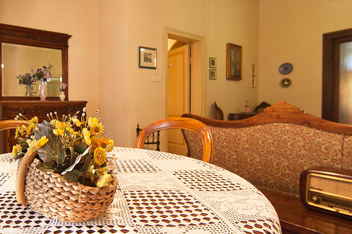 En matplats med ett runt bord, en flätad korg med blommor, en spetsduk och en trästol.