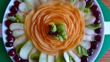Un piatto con fettine di mele e uva disposte a cerchio, con una fetta di mela al centro.