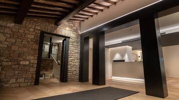 Un intérieur moderne avec des murs en pierre apparents, des poutres en bois et un design minimaliste.