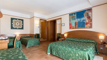 Une chambre d’hôtel avec deux lits, un bureau et un tableau au mur.