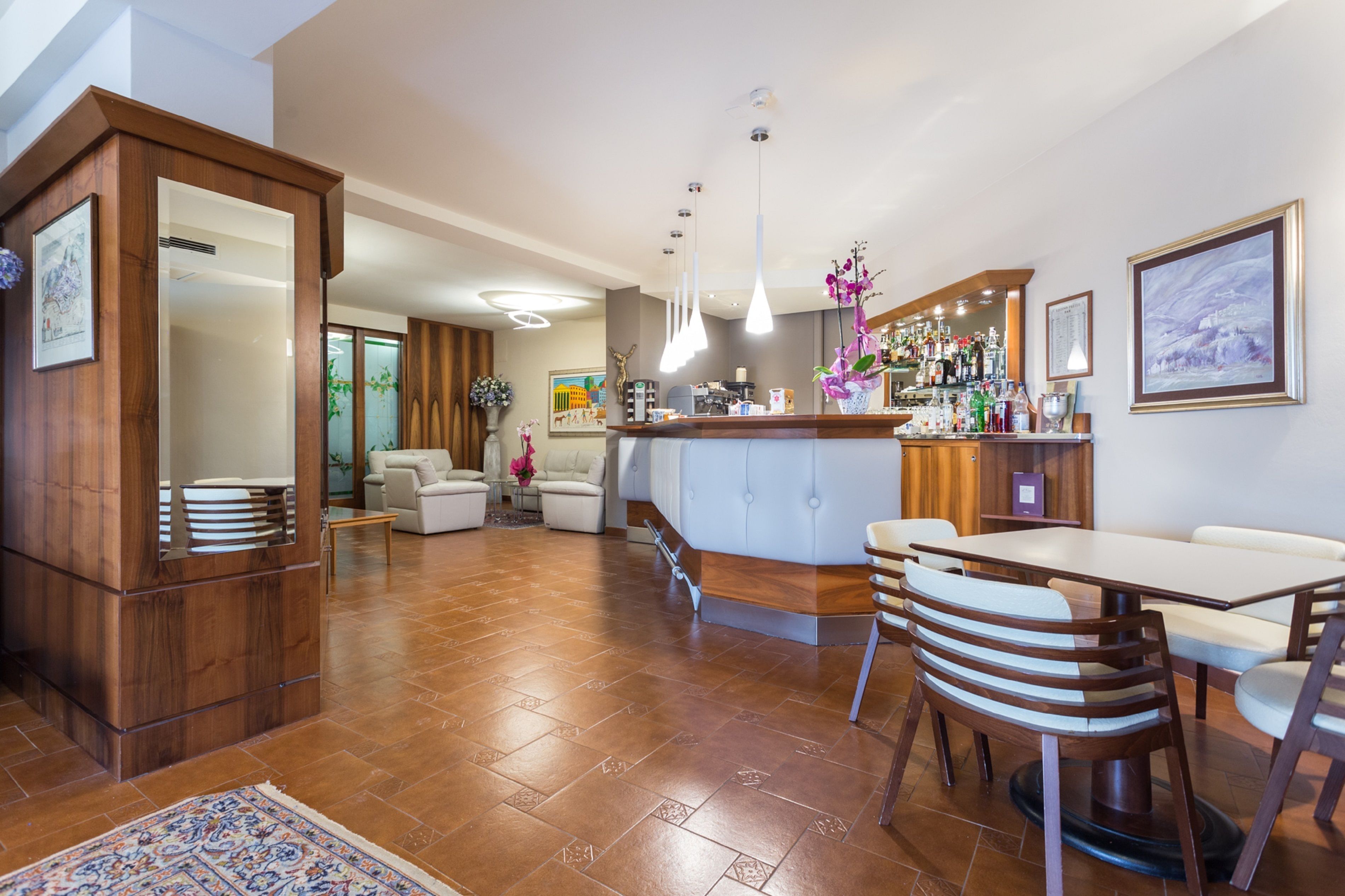 A modern kitchen with a bar area, wooden cabinetry, and a dining set.