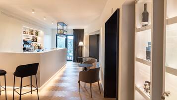Una cucina moderna con zona bar, pavimento in legno e vista sull'esterno.