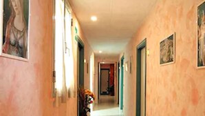 Un corridoio con una panchina, porte e quadri appesi alle pareti.