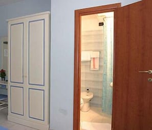Un baño con inodoro, lavamanos y espejo.