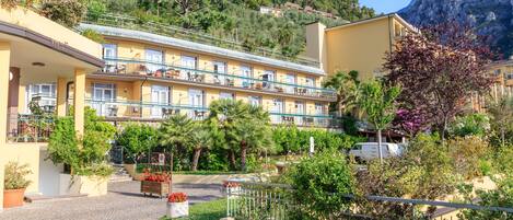 A hotel with a courtyard, balconies, and a mountain backdrop.