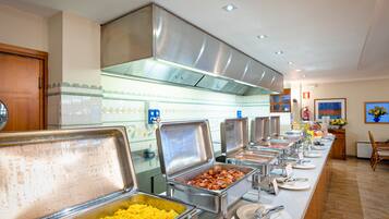 A buffet area with various food stations, including a section for scrambled eggs and another for bacon.