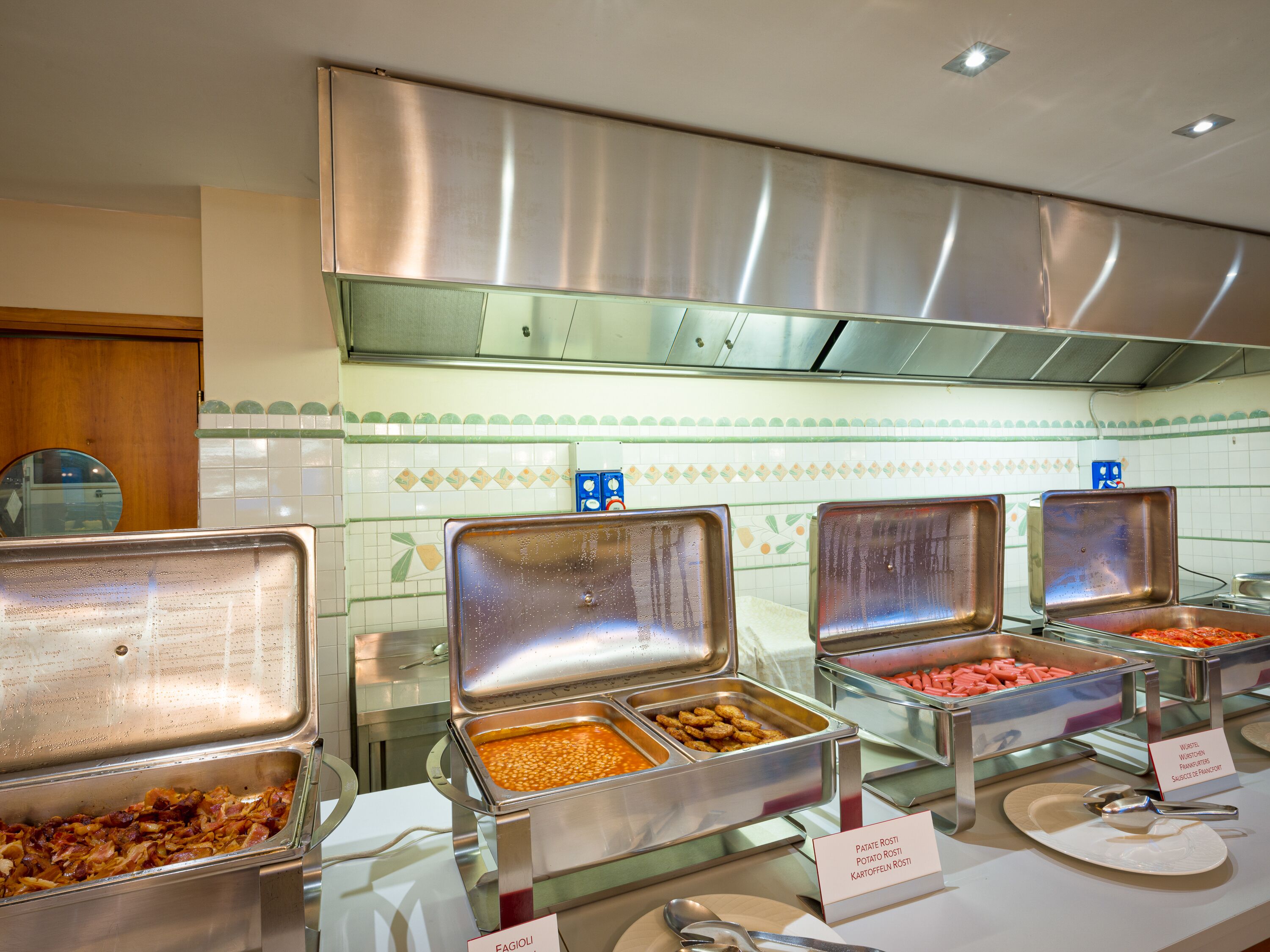 A buffet with various food options, including pasta, salads, and meats.