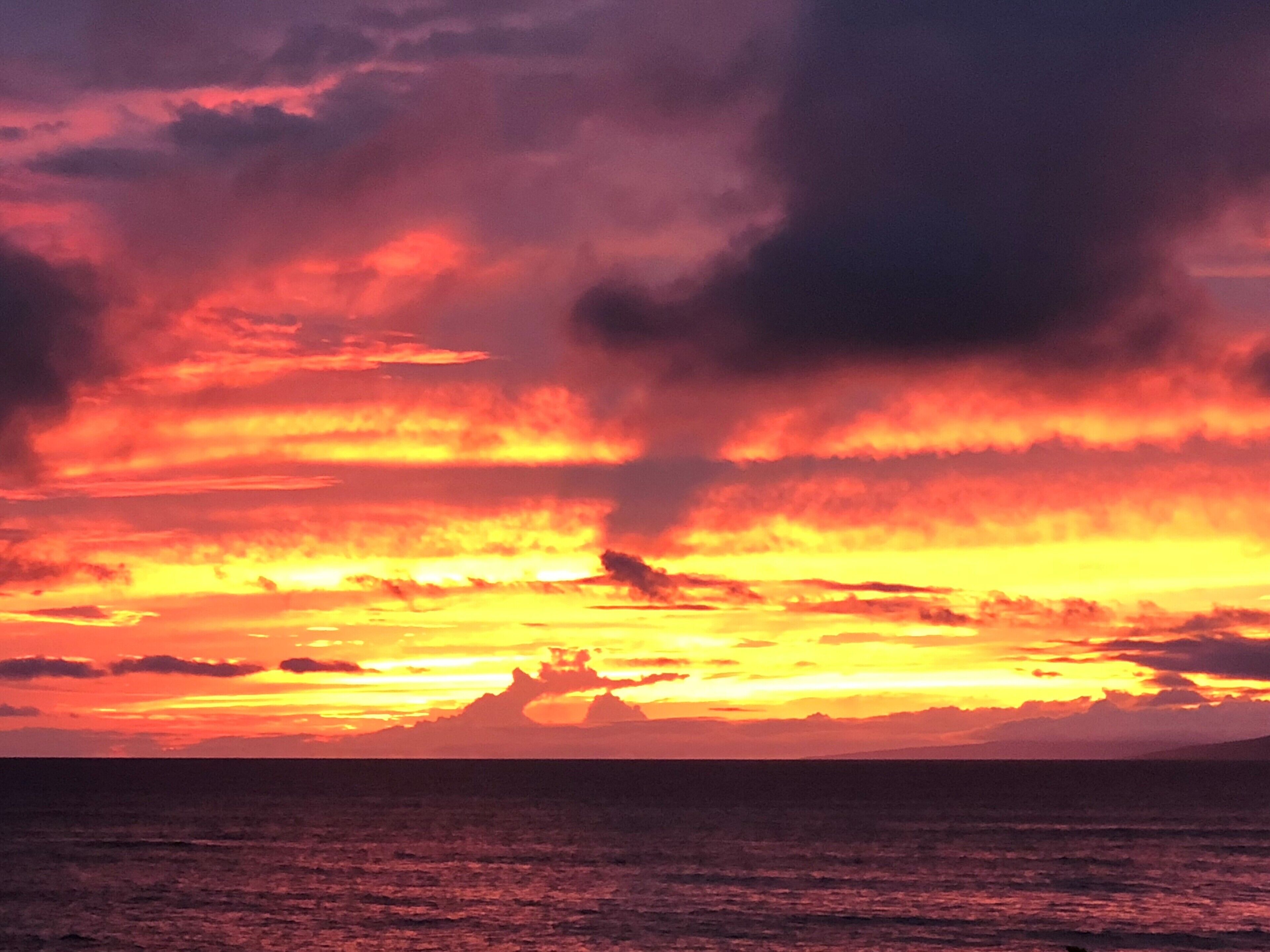 Ein Sonnenuntergang über dem Meer mit Wolken.