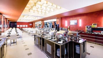 Montaje de bufé con múltiples estaciones de servicio, un mostrador central y un área de comedor con mesas y sillas.
