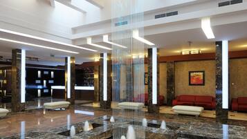 Experience the tranquil ambiance of our lobby, featuring a central water feature and high ceilings with geometric patterns.
